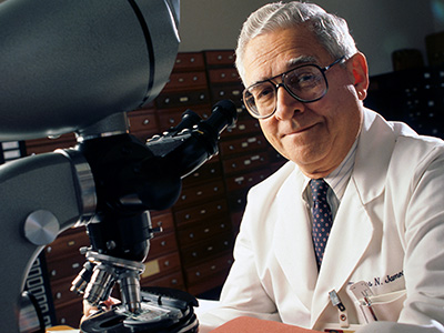 Dr. Thomas N. James, who became the third president of UTMB in 1987, pictured beside a microscope.