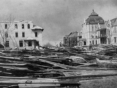 Historic photograph showing storm debris and damaged buildings near the UTMB campus after the 1900 Galveston hurricane. UTMB After the 1900 Galveston Storm