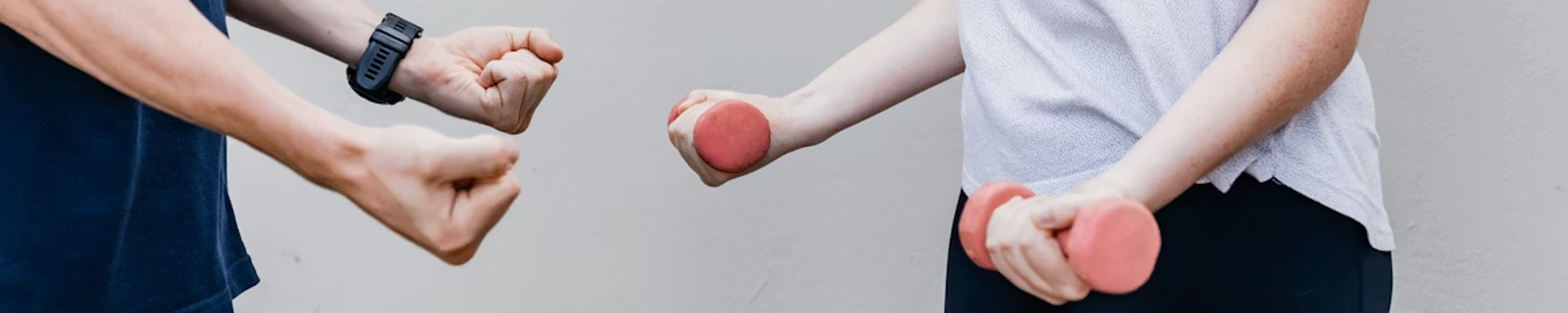 Two people perform arm exercises with hand weights, representing rehabilitation, physical function, and health services research.